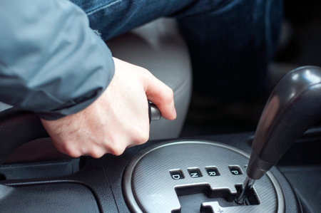 driver pulling the hand brake in car