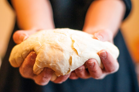 Woomens hands holding a finished clean dough