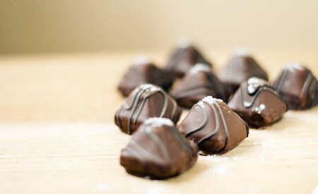 Chocolate truffle candies with sea salt. Salted chocolate piled on a wood texture background. Shallow depth of field with selective focus on one truffle.の写真素材