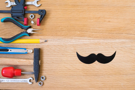 Happy fathers day sticker, tools, black paper mustache on wooden background