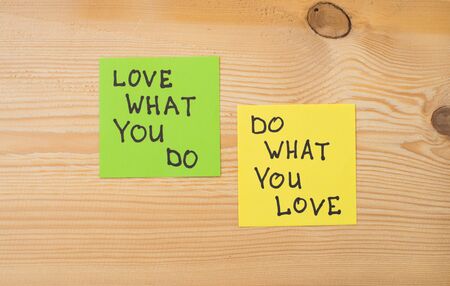 Yellow and green note paper w on rustic wooden background. 'Love What You Do and Do What You Love' notes . I love my job conceptの写真素材