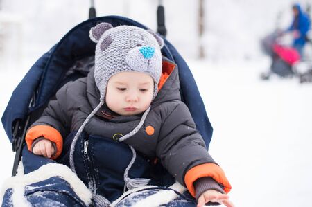 Little girl enjoying a sleigh ride. Child sledding. Toddler kid riding a sledge. Children play outdoors in snow. Kids sled in the Alps mountains in winter. Outdoor fun for family Christmas vacation.の写真素材