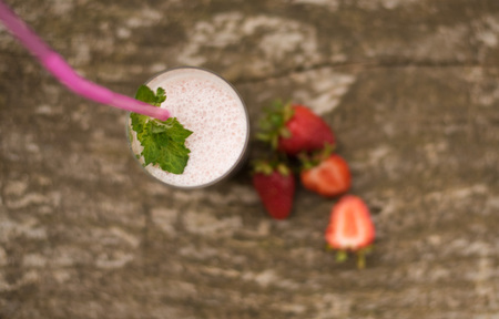 Delicious strawberry smoothie close-up. 
strawberry milkshake with whipped cream on a dark wood background. tinting. selective focusの写真素材