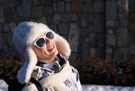 
Funny little girl in sunglasses in winter   a sunny day.  Caucasian stylish little girl in winter clothes walking outdoor. Pretty charming little girl. Portrait of little fashion kid girl .の写真素材