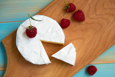 cheese camembert with raspberries and grapes tableの写真素材