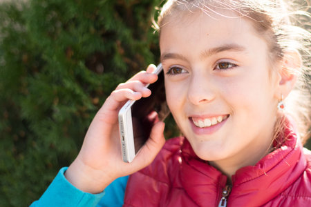 Beautiful girl talking on a smartphone in red vest