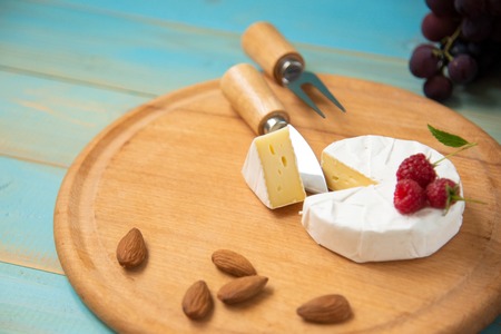 cheese camembert with raspberries and grapes onの写真素材