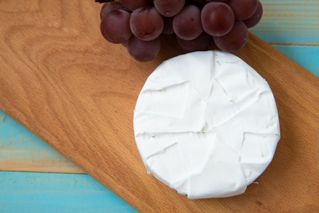 cheese camembert with a fork for cheese and grapeの写真素材