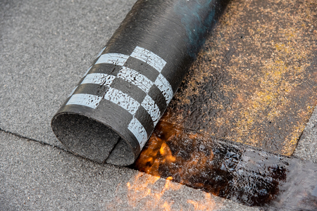 Preheating the edges of the roofing material.の写真素材