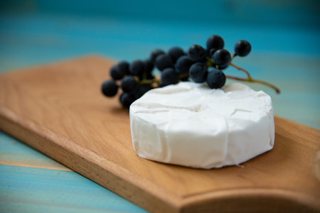 cheese camembert on blue wooden background top view