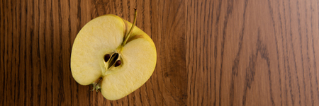 Half the yellow apple , on the dark wooden background . Copy space. Top view.の写真素材