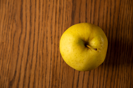 Yellow apple, on the dark wooden background. Top view. Copy space.の写真素材