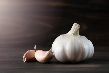 Garlic Cloves and Bulb on dark wooden table background. Copy space.の写真素材