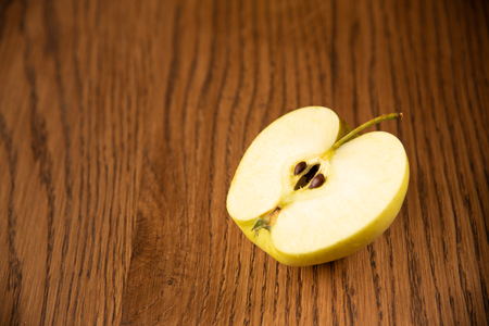Yellow apple on the wooden vintage backgroundの写真素材