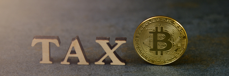 Bitcoin and wooden letters TAX on stone backgroundの写真素材