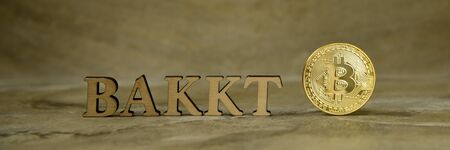 Bitcoin coin and next to wooden with BAKKTのeditorial素材