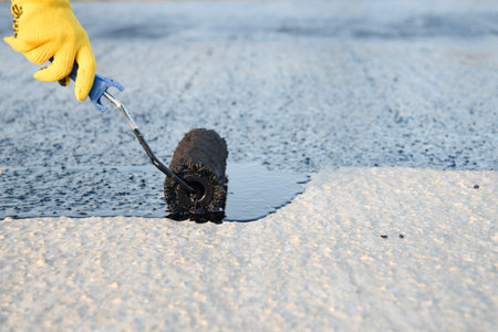 Worker applies bitumen mastic on the foundation