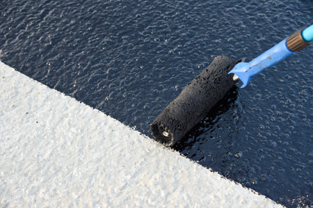 Roller brush waterproofing. Waterproofing coating. Copy space. Space for text.
