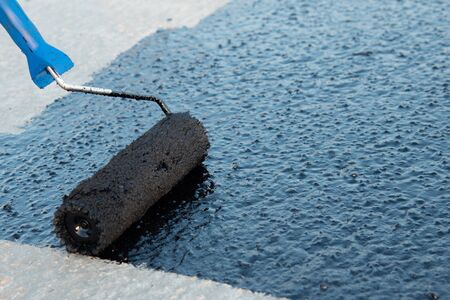 Roller brush waterproofing. Waterproofing coating. Copy space. Space for text.の写真素材