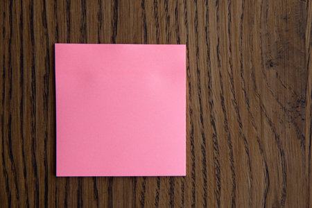 Colorful sticky notes on wooden background.