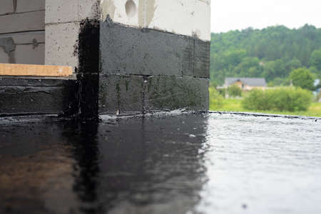 the terrace is covered with a layer of waterproofing mastic, on a background of green grass. Copy spaceの写真素材