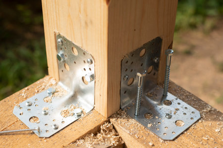 Construction of a timber frame house. Joining wooden beams using a galvanized metal corner and...