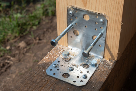 Construction of a timber frame house. Joining wooden beams using a galvanized metal corner and self-tapping screws. Timber frame construction details.の写真素材