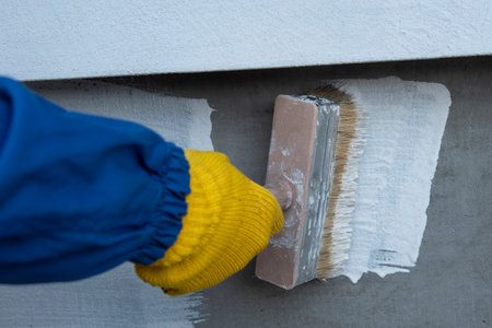 Cover the concrete wall with a cement-polymer waterproofing membrane. Waterproofing with a white shade brush. The waterproofing coating is white.の写真素材
