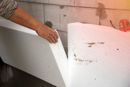 A builder installs polystyrene foam sheets. The process of thermal insulation of the walls of the house. Thermal insulation.の写真素材