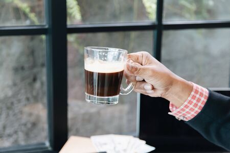 Cropped shot of man holding a cup of coffee in the morning. Hipster lifestyle, Travel inspiration, Cafe shop.の写真素材