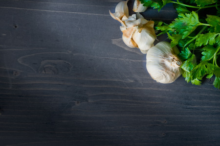 Garlic and a bunch of parsley on woodboardの写真素材