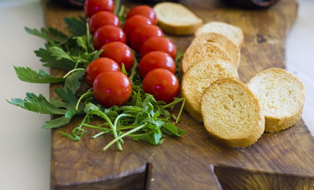 A delicious appetizer with cherry tomatoes, arugula and bruschettaの写真素材