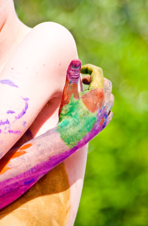 children playing making colorful designs with hands dipped in colored dyeの写真素材