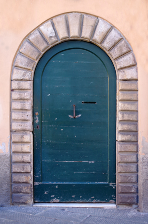 Ancient wooden door with hinges and knocker wrought iron handicraftの写真素材