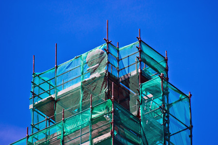 scaffolding of iron pipes and green network used for the restoration of ancient buildings and recordsの写真素材