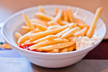 plate of hot and fragrant fries with mayonnaise and ketchup