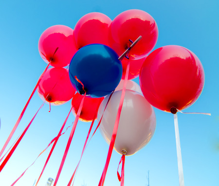many colorful balloons launched from the children happy flying in the blue skyの写真素材