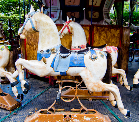 old horse of a colorful carousel of tan, red and blueの写真素材