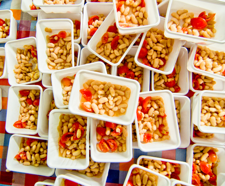 bowls with beans seasoned with salt, oil and cherry tomatoes ready to be brought to the tableの写真素材