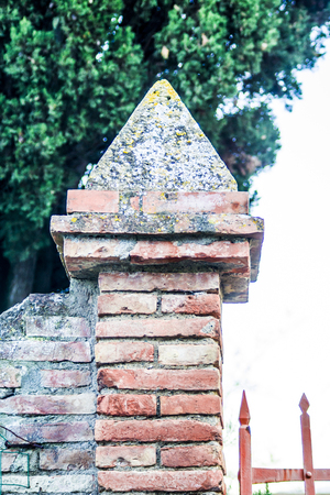 brick pillar supporting a gate with a brick pyramid on topの写真素材