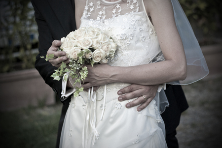 fingers of the young spouses play touch rings of love that they have given themselves for the whole life and with the bouquetの写真素材