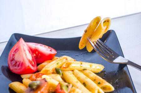 nourishing and healthy pasta, macaroni with colorful and tasty vegetables and capers