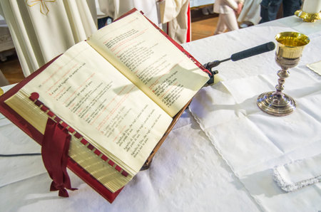 chalice with wine, blood of christ, and the book of mass on the altar of the church