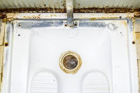 dirty, unclean Turkish bath, used by several people and with traces of limestone and rustの写真素材