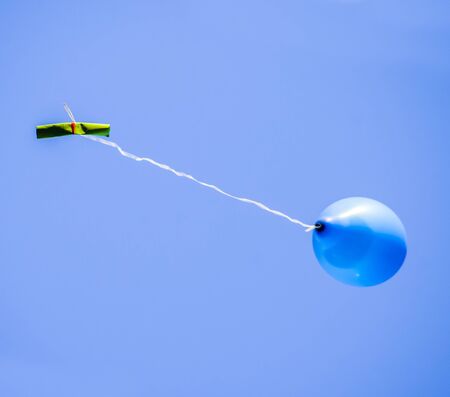 colorful balloons flying in the blue sky with a message of peace and friendship written by childrenの写真素材