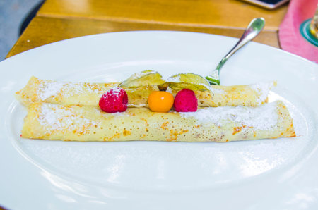 crepes filled with chocolate and berries with wild strawberries and cape gooseberries