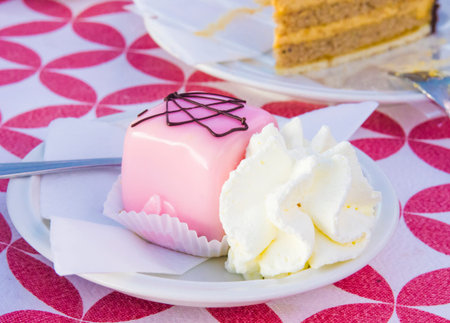 single-twist vanilla and chocolate sponge cakes covered with strawberry icing served with whipped...