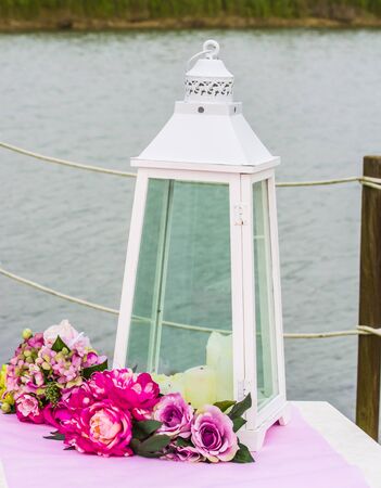 outdoor table decorated in white, pink and fuchsia with candles and fragrant flowers for your partyの写真素材