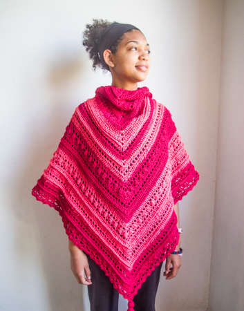 Elegant red and pink poncho or shawl tied by a young smiling and happy Brazilian modelの写真素材