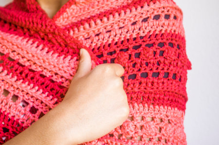 Elegant red and pink poncho or shawl tied by a young smiling and happy Brazilian model